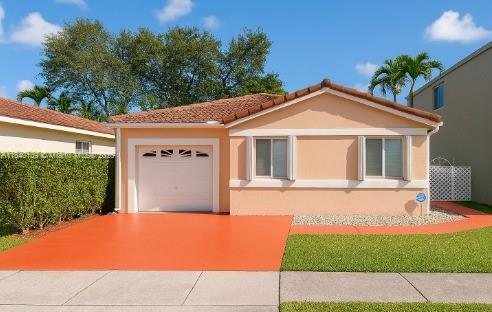 16907 SW 142nd Pl, Miami, FL 33177 - view of front facade with an attached garage, driveway, and stucco siding