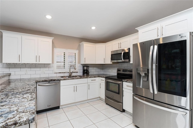 1710 SW 100th Ter, Davie, FL 33324 - kitchen featuring appliances with stainless steel finishes, decorative backsplash, white cabinetry, dark stone counters, and recessed lighting