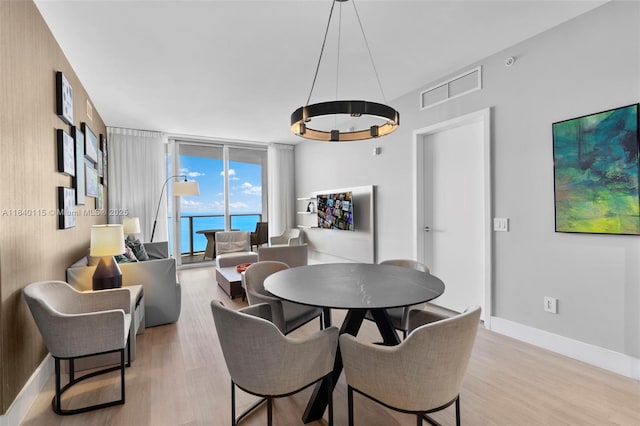 4111 S Ocean Dr Unit 2906, Hollywood, FL 33019 - dining space featuring light wood-type flooring, a wall of windows, and a chandelier