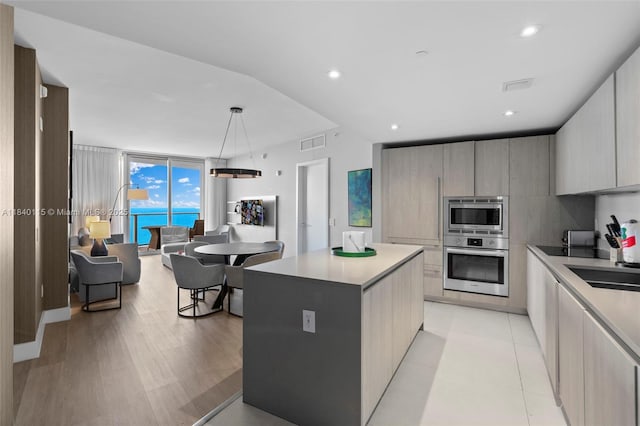 4111 S Ocean Dr Unit 2906, Hollywood, FL 33019 - kitchen featuring stainless steel appliances, modern cabinets, a kitchen island, light countertops, and pendant lighting