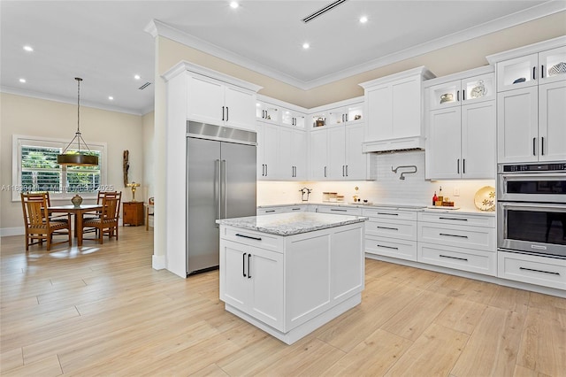 11971 Torreyanna, West Palm Beach, FL 33412 - kitchen with appliances with stainless steel finishes, ornamental molding, light wood-type flooring, a center island, and backsplash