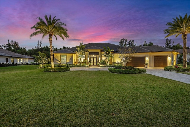 11971 Torreyanna, West Palm Beach, FL 33412 - prairie-style home featuring decorative driveway, a garage, a front lawn, stucco siding, and french doors