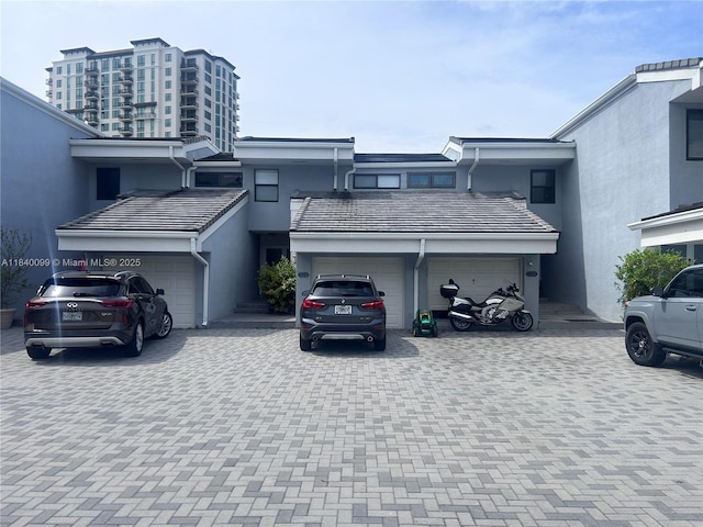 324 Poinciana Dr Unit 906, Sunny Isles Beach, FL 33160 - view of front facade with stucco siding, decorative driveway, and an attached garage
