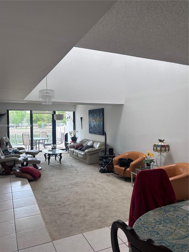 324 Poinciana Dr Unit 906, Sunny Isles Beach, FL 33160 - living area with carpet floors, tile patterned flooring, high vaulted ceiling, and a chandelier