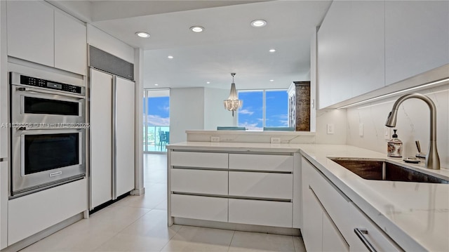20201 E Country Club Dr Unit 1202, Aventura, FL 33180 - kitchen with paneled fridge, stainless steel double oven, white cabinets, modern cabinets, and recessed lighting