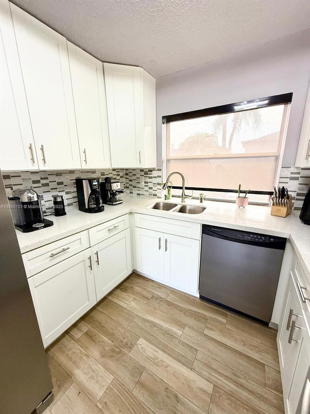 6169 NW 170th Ter, Hialeah, FL 33015 - kitchen featuring dishwasher, backsplash, light countertops, white cabinets, and light wood-type flooring