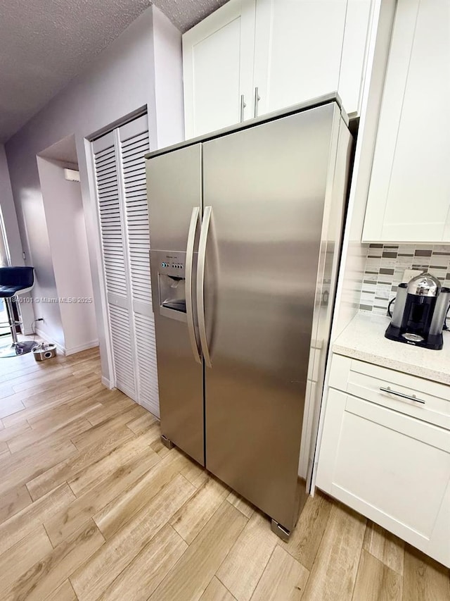 6169 NW 170th Ter, Hialeah, FL 33015 - kitchen featuring stainless steel fridge with ice dispenser, light wood finished floors, and white cabinets