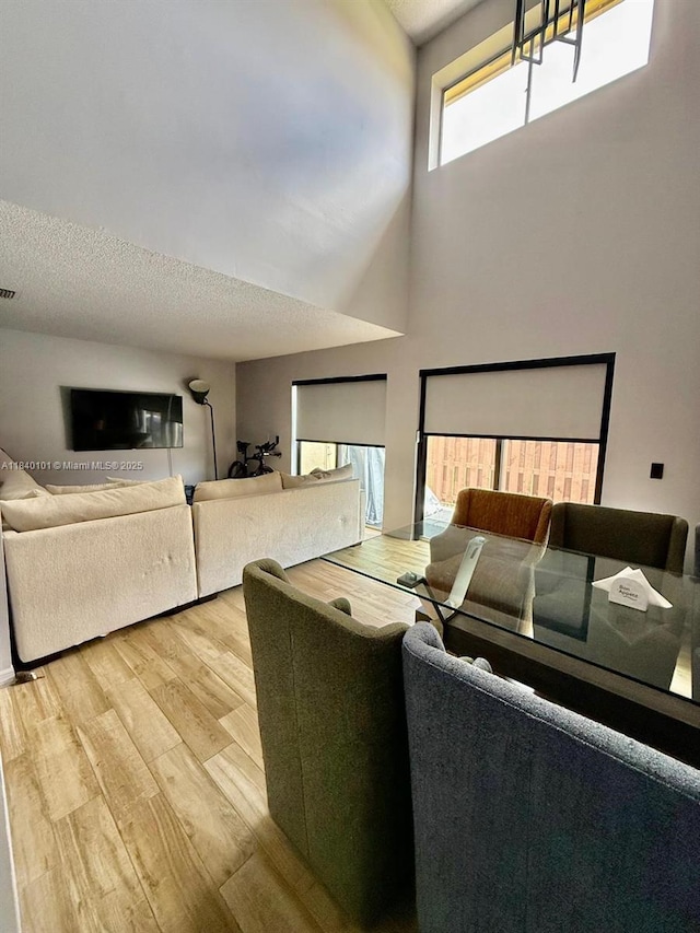 6169 NW 170th Ter, Hialeah, FL 33015 - living room with wood finished floors, a high ceiling, and a textured ceiling