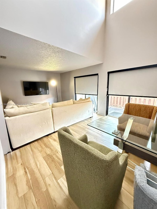 6169 NW 170th Ter, Hialeah, FL 33015 - living room with wood finished floors, a textured ceiling, and a high ceiling