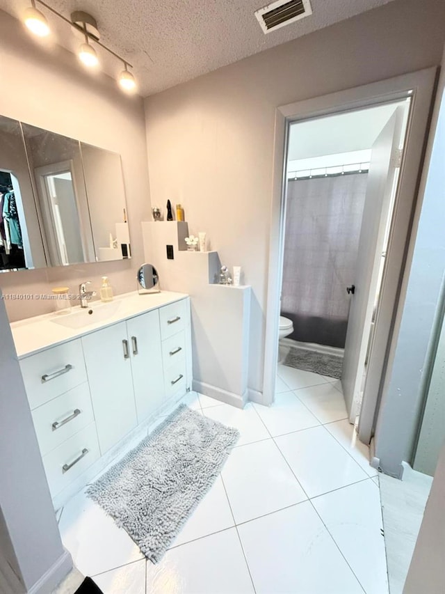 6169 NW 170th Ter, Hialeah, FL 33015 - full bathroom with vanity, a textured ceiling, tile patterned floors, and track lighting