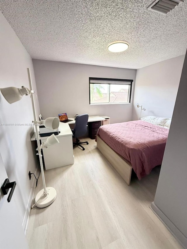 6169 NW 170th Ter, Hialeah, FL 33015 - bedroom featuring light wood-type flooring, a desk, and a textured ceiling
