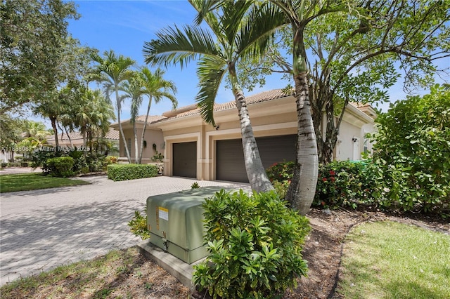 932 NW 123rd Dr, Coral Springs, FL 33071 - mediterranean / spanish-style house featuring stucco siding, an attached garage, decorative driveway, and a tiled roof