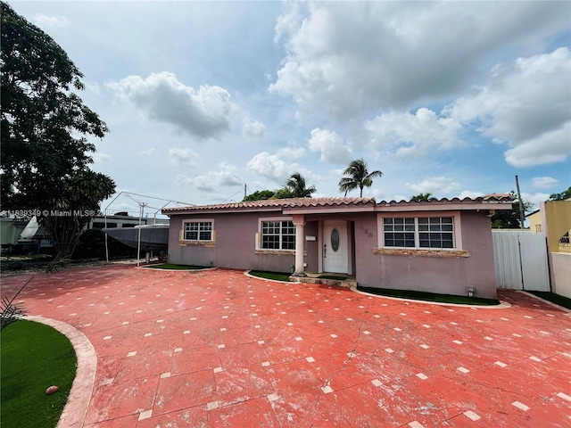 180 E 46th St, Hialeah, FL 33013 - view of front of home featuring stucco siding, a patio area, and a tiled roof