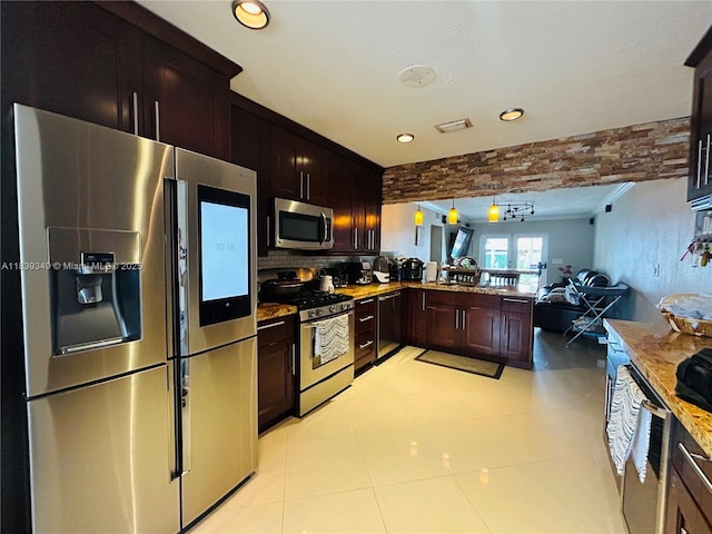 180 E 46th St, Hialeah, FL 33013 - kitchen with appliances with stainless steel finishes, open floor plan, a peninsula, tasteful backsplash, and dark brown cabinetry
