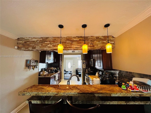 180 E 46th St, Hialeah, FL 33013 - kitchen featuring tasteful backsplash, hanging light fixtures, stainless steel appliances, a peninsula, and dark brown cabinets