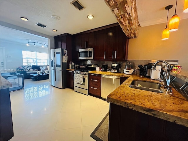180 E 46th St, Hialeah, FL 33013 - kitchen featuring appliances with stainless steel finishes, decorative backsplash, decorative light fixtures, light stone countertops, and light tile patterned floors