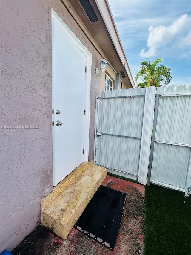 180 E 46th St, Hialeah, FL 33013 - doorway to property featuring stucco siding and a gate