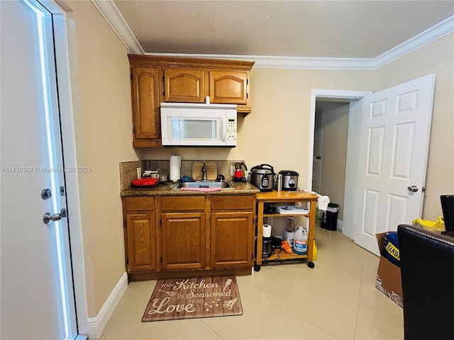 180 E 46th St, Hialeah, FL 33013 - kitchen featuring white microwave, ornamental molding, brown cabinetry, and light tile patterned floors
