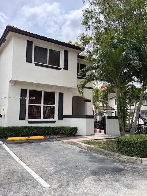 8625 SW 152nd Ave Unit 250, Miami, FL 33193 - view of front of home with uncovered parking, stucco siding, and a gate