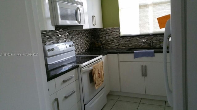 8625 SW 152nd Ave Unit 250, Miami, FL 33193 - kitchen featuring white appliances, white cabinets, dark countertops, and decorative backsplash