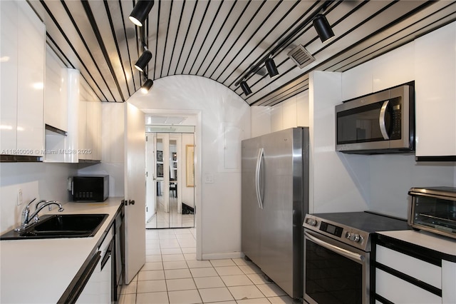 1800 NE 114th St Unit Ph06, Miami, FL 33181 - kitchen with appliances with stainless steel finishes, white cabinetry, light tile patterned floors, and modern cabinets