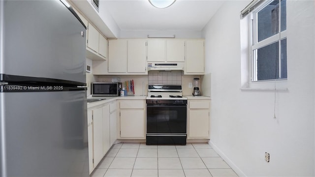 1033 Lenox Ave Unit 304, Miami Beach, FL 33139 - kitchen with appliances with stainless steel finishes, under cabinet range hood, light countertops, light tile patterned flooring, and tasteful backsplash