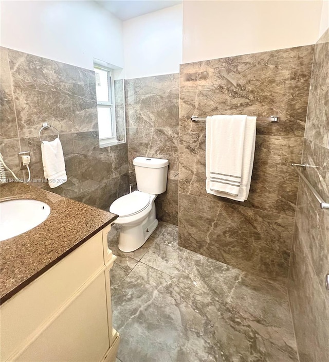 9130 SW 17th Ter, Miami, FL 33165 - bathroom featuring tile walls, vanity, marble finish flooring, and wainscoting