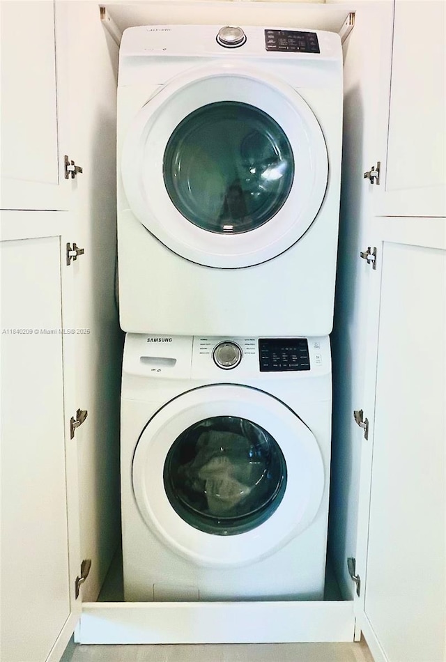 9130 SW 17th Ter, Miami, FL 33165 - washroom featuring stacked washing machine and dryer and cabinet space