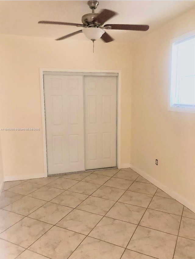 9130 SW 17th Ter, Miami, FL 33165 - unfurnished bedroom featuring a closet, light tile patterned flooring, and a ceiling fan