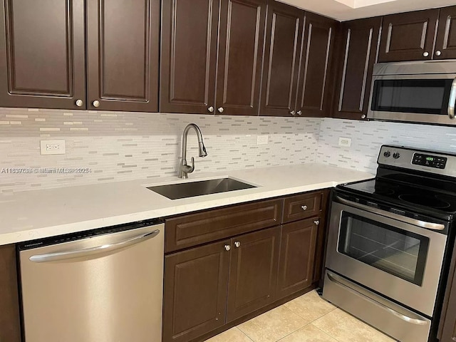 3690 N 56th Ave Unit 916, Hollywood, FL 33021 - kitchen with stainless steel appliances, light tile patterned floors, tasteful backsplash, light countertops, and dark brown cabinetry