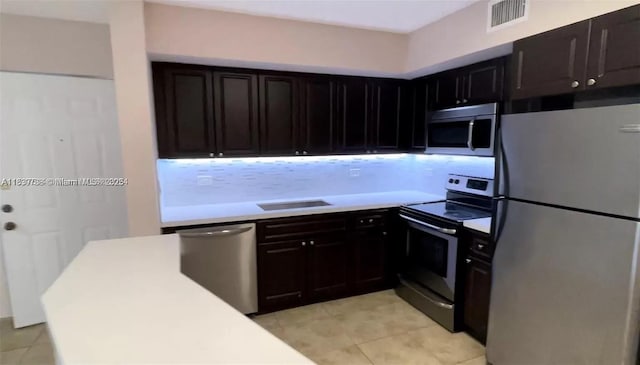 3690 N 56th Ave Unit 916, Hollywood, FL 33021 - kitchen featuring stainless steel appliances, light countertops, light tile patterned flooring, decorative backsplash, and dark cabinets