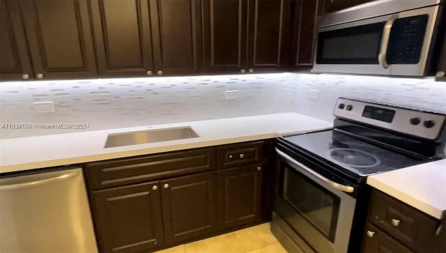 3690 N 56th Ave Unit 916, Hollywood, FL 33021 - kitchen featuring appliances with stainless steel finishes, light countertops, dark brown cabinets, light tile patterned flooring, and tasteful backsplash