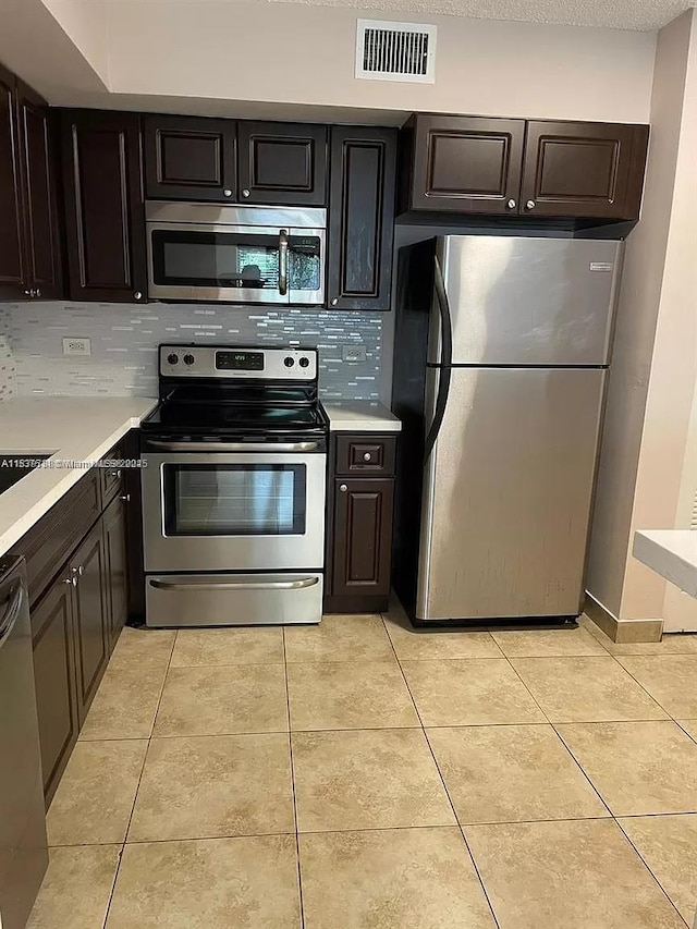 3690 N 56th Ave Unit 916, Hollywood, FL 33021 - kitchen with stainless steel appliances, light countertops, backsplash, and light tile patterned flooring