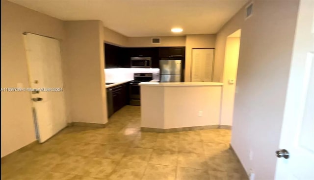 3690 N 56th Ave Unit 916, Hollywood, FL 33021 - kitchen featuring appliances with stainless steel finishes, a peninsula, light tile patterned floors, and light countertops