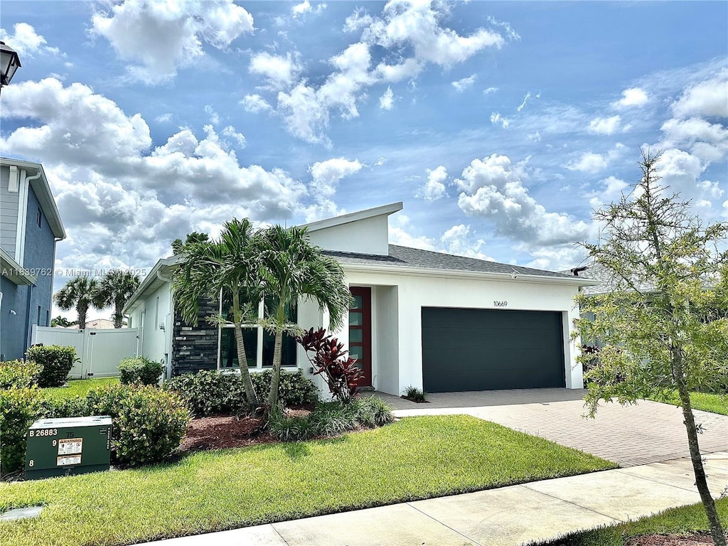 10669 SW Gloriana St, Port St Lucie, FL 34987 - view of front facade featuring stucco siding, driveway, and an attached garage