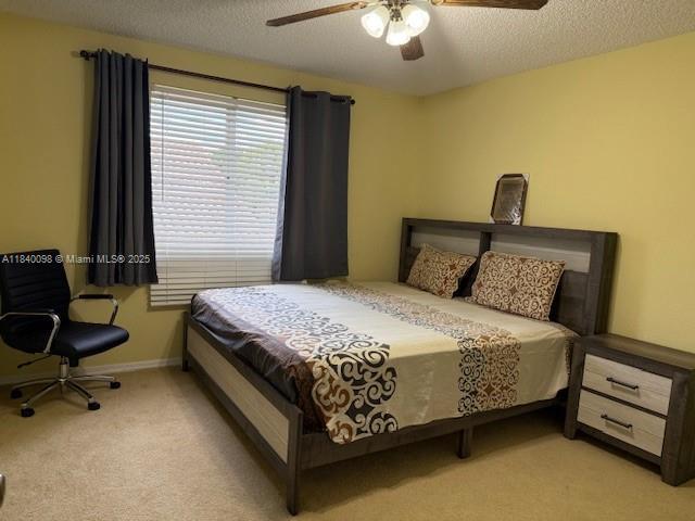 13063 NW 11th Ct, Sunrise, FL 33323 - bedroom with carpet, a ceiling fan, and a textured ceiling