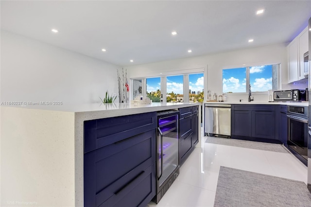16479 NE 27th Pl Unit 16, North Miami Beach, FL 33160 - kitchen with appliances with stainless steel finishes, beverage cooler, recessed lighting, light countertops, and healthy amount of natural light