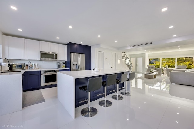 16479 NE 27th Pl Unit 16, North Miami Beach, FL 33160 - kitchen with appliances with stainless steel finishes, a breakfast bar area, open floor plan, light countertops, and recessed lighting
