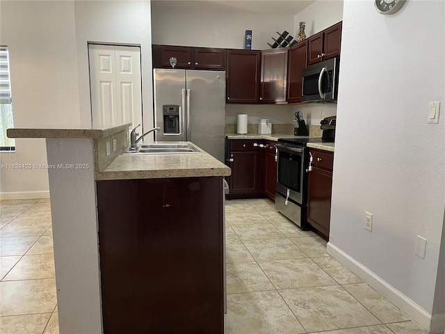 730 SE 34th Ave, Homestead, FL 33033 - kitchen with stainless steel appliances, a kitchen island with sink, light tile patterned flooring, and light countertops