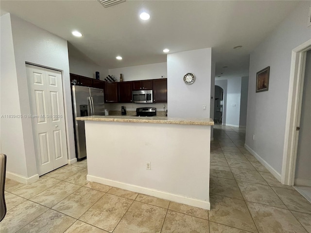 730 SE 34th Ave, Homestead, FL 33033 - kitchen featuring appliances with stainless steel finishes, light countertops, dark brown cabinetry, light tile patterned flooring, and recessed lighting