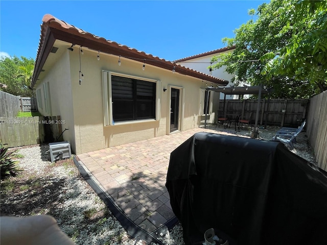 730 SE 34th Ave, Homestead, FL 33033 - rear view of house featuring stucco siding, a patio, a tile roof, and a fenced backyard