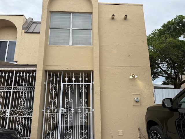 3860 W 11th Ln, Hialeah, FL 33012 - view of side of property featuring stucco siding and a gate