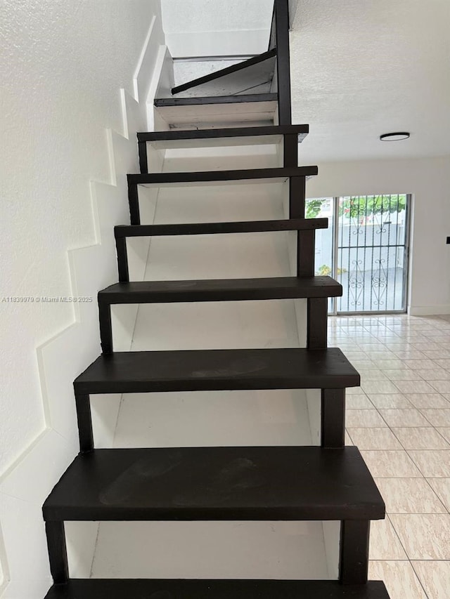3860 W 11th Ln, Hialeah, FL 33012 - staircase featuring a textured ceiling and tile patterned floors