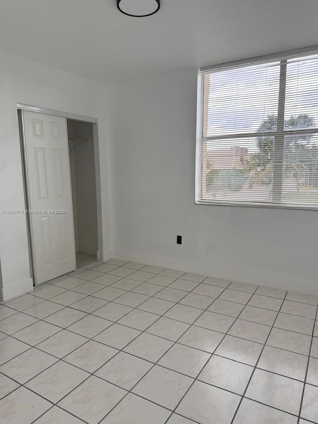 3860 W 11th Ln, Hialeah, FL 33012 - unfurnished bedroom featuring a closet and light tile patterned flooring