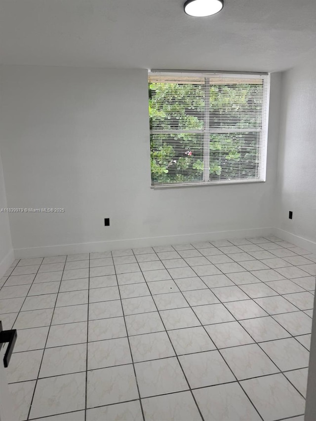 3860 W 11th Ln, Hialeah, FL 33012 - unfurnished room with healthy amount of natural light and light tile patterned flooring