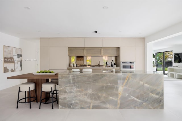 7805 SW 165th St, Palmetto Bay, FL 33157 - kitchen featuring oven, stainless steel counters, modern cabinets, and a breakfast bar area