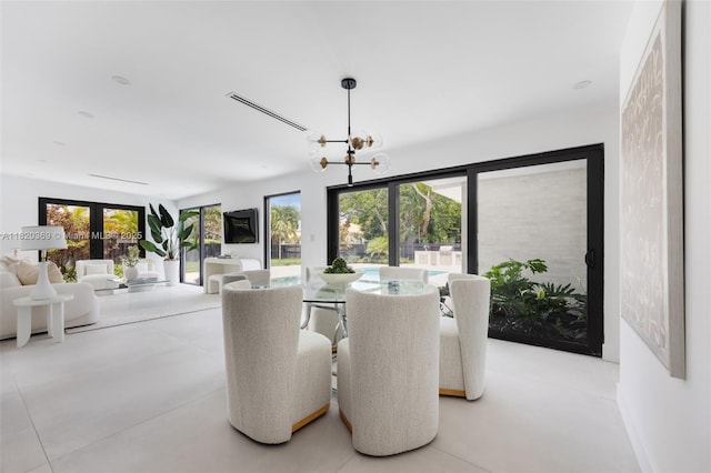 7805 SW 165th St, Palmetto Bay, FL 33157 - dining area with french doors, a chandelier, and concrete flooring