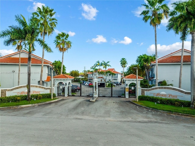 11647 NE 18th Dr Unit 11647, North Miami, FL 33181 - view of asphalt street with a gate, curbs, a residential view, and a gated entry