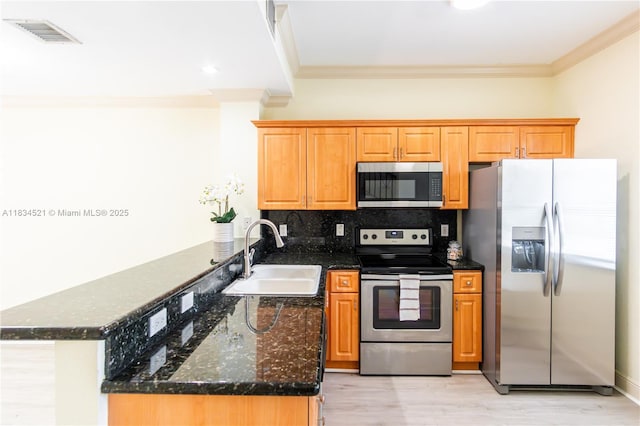 11647 NE 18th Dr Unit 11647, North Miami, FL 33181 - kitchen featuring stainless steel appliances, crown molding, a peninsula, decorative backsplash, and dark stone counters