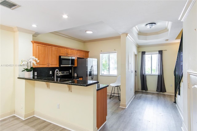 11647 NE 18th Dr Unit 11647, North Miami, FL 33181 - kitchen with appliances with stainless steel finishes, ornamental molding, brown cabinets, dark stone counters, and a breakfast bar area